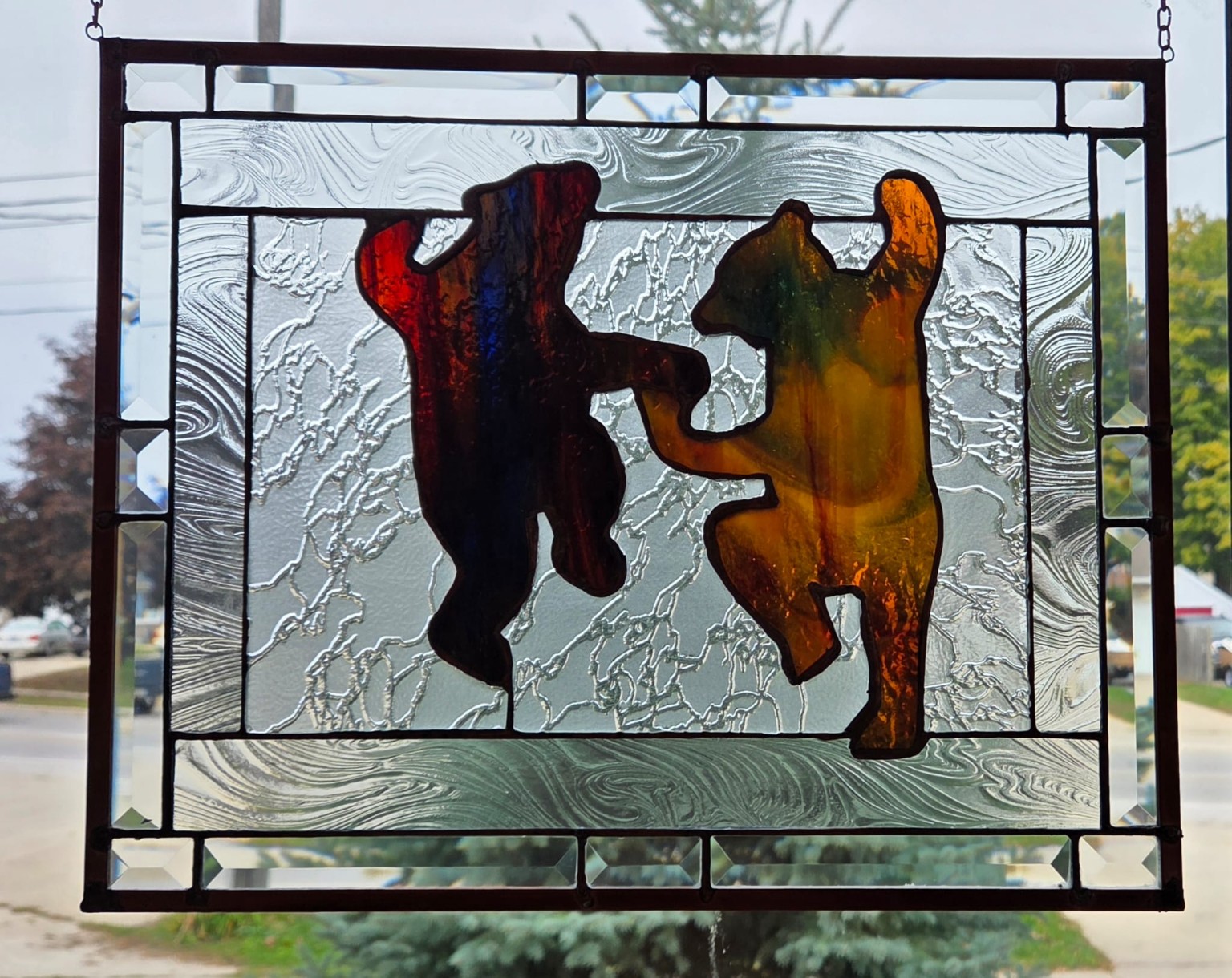 Two dancing bears in a textured stained-glass panel