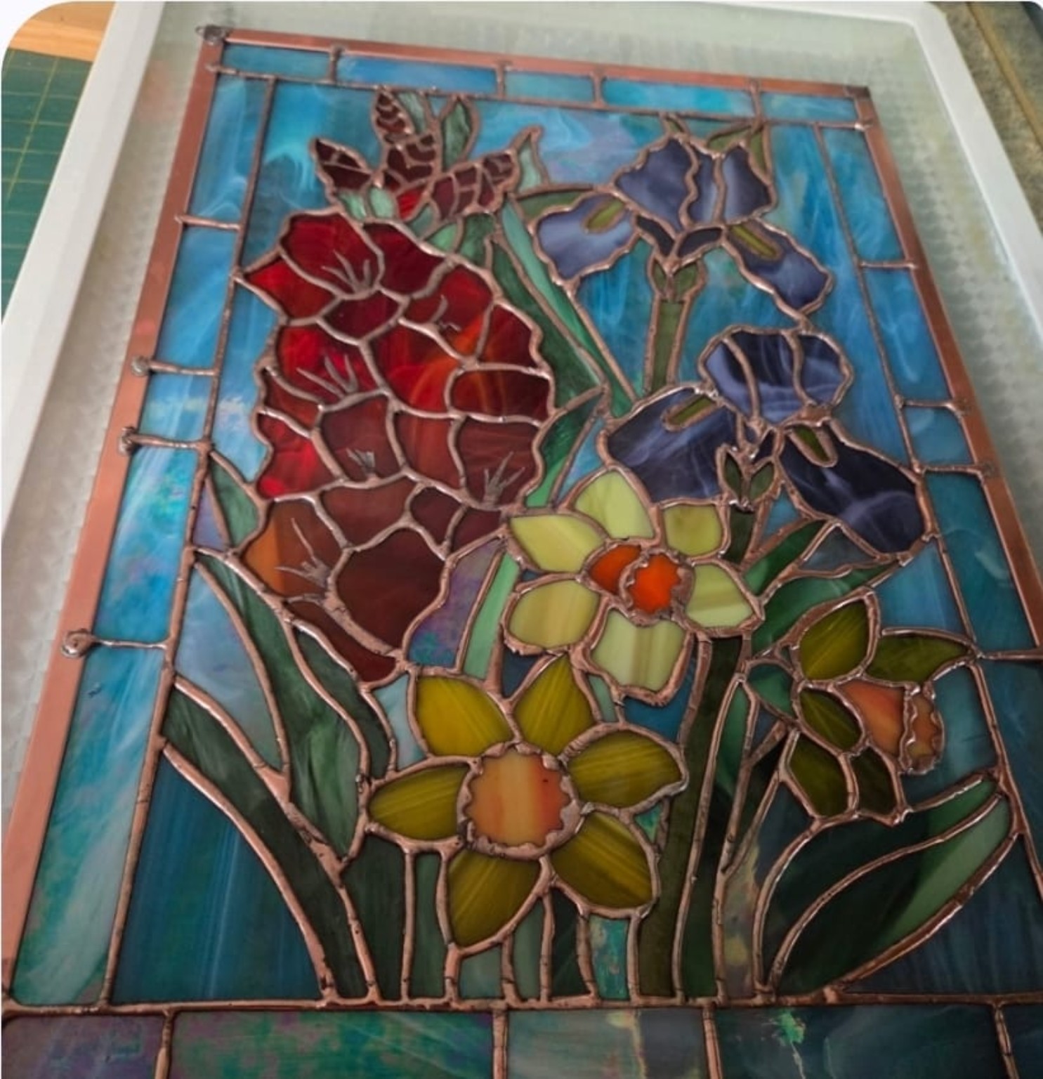 The floral stained-glass panel being assembled